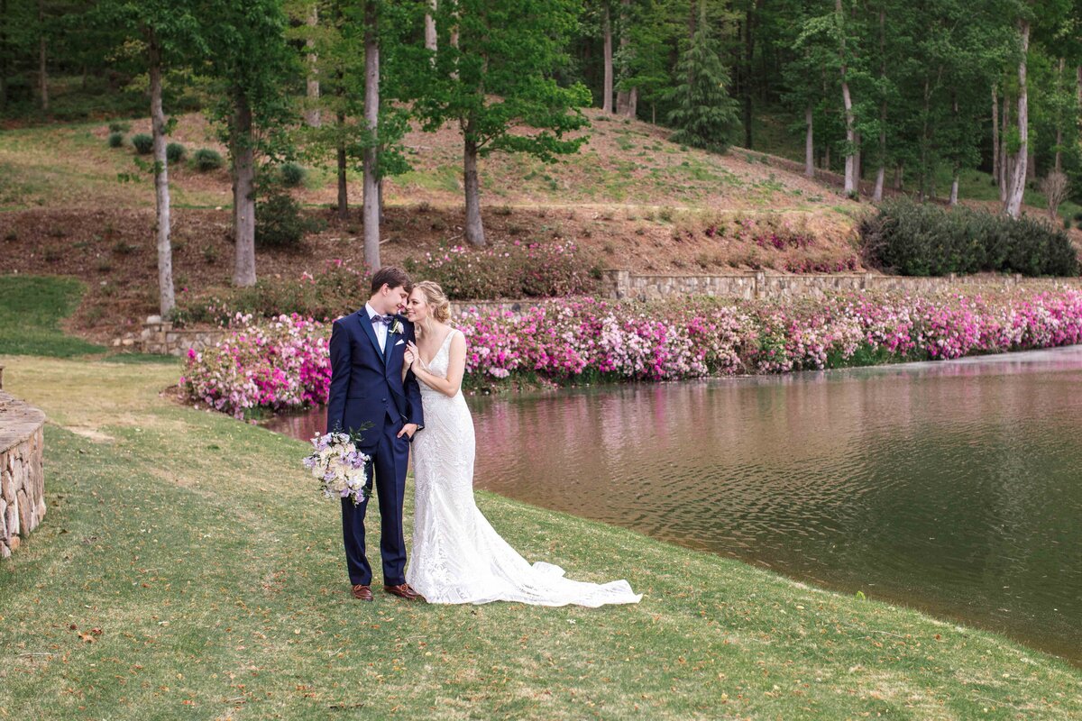 wedding photographer in Texas captures bride and groom with azalea lined lake
