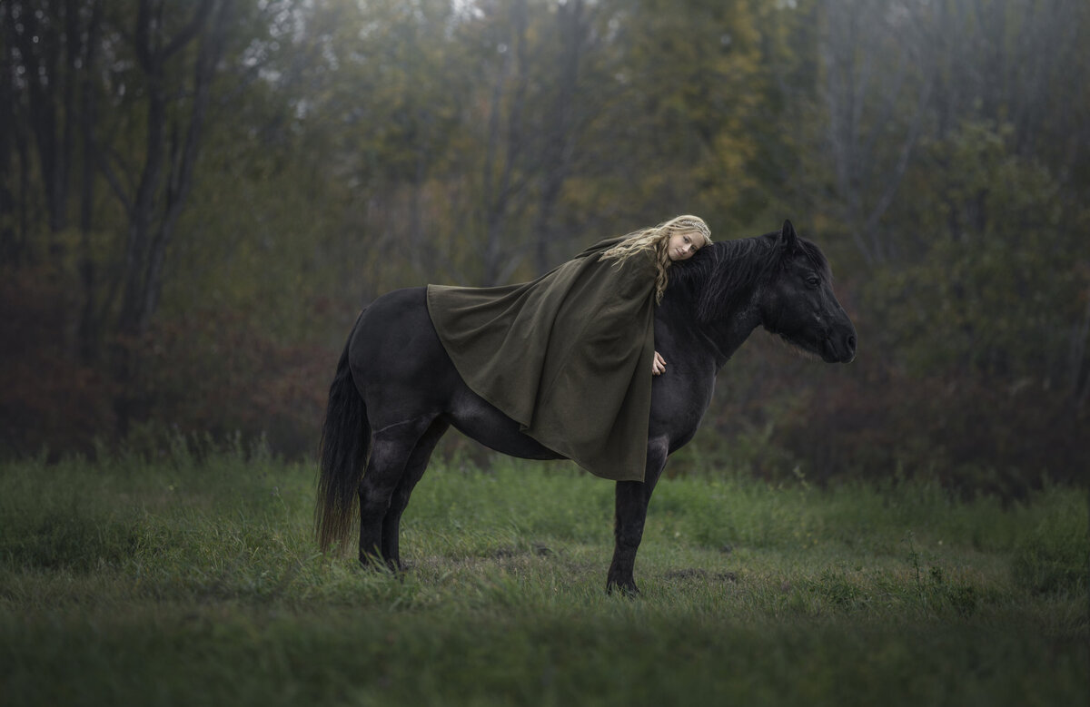girl  lying on erh horse during her outdoor photo shoot in the fall in Ottawa Ontario
