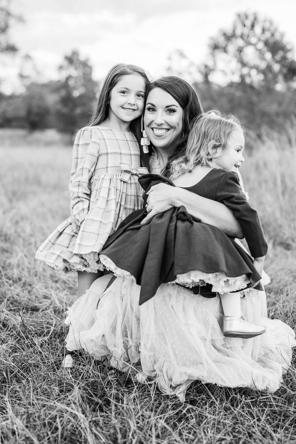 A black and white photo of a mom with her two daughters. Captured by Jackson MS Photographer Jessica Greene.