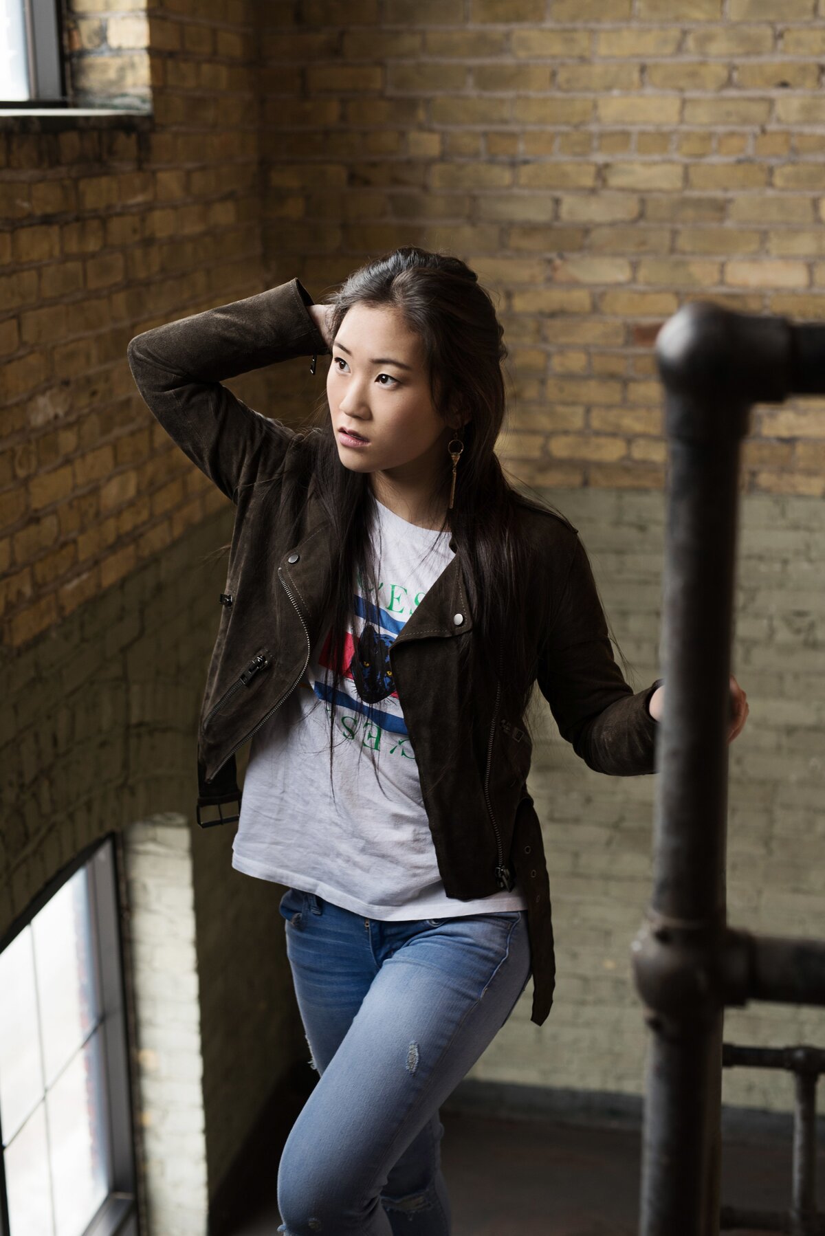 Wayzata Minnesota senior photo of girl standing on stairs looking out window in Minneapolis MN studio