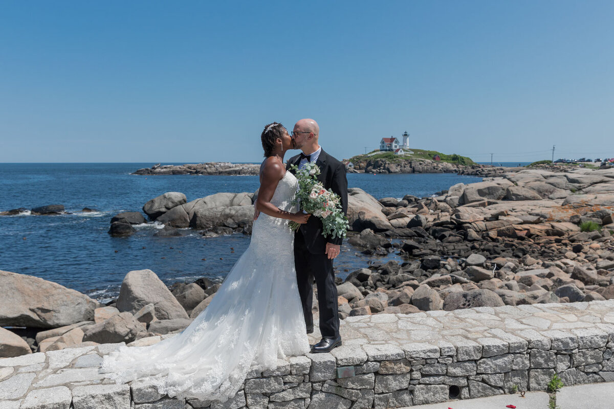 Bride and groom kissing by the seaside