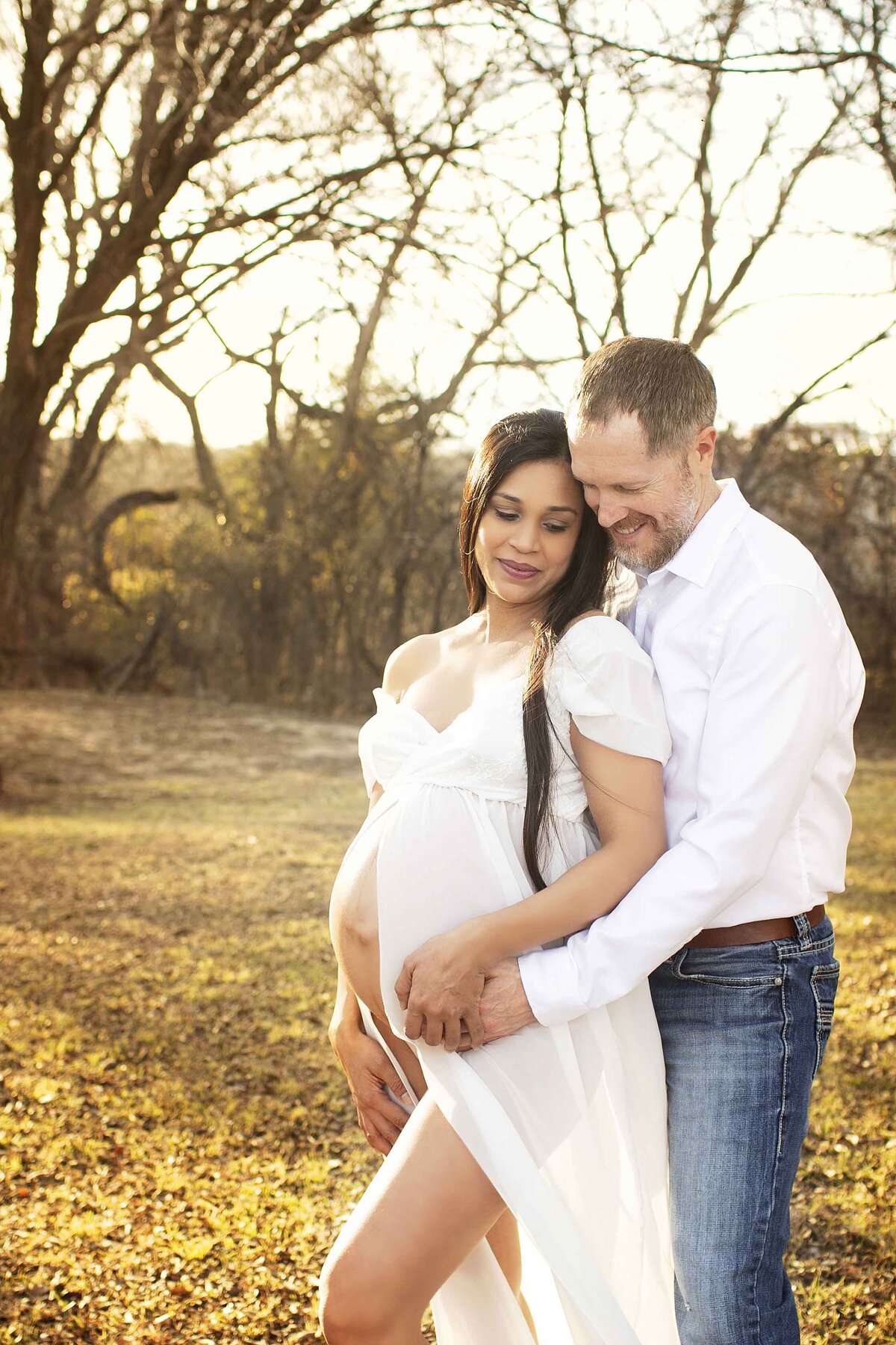 Couple posing at their maternity shoot with Heather Bush