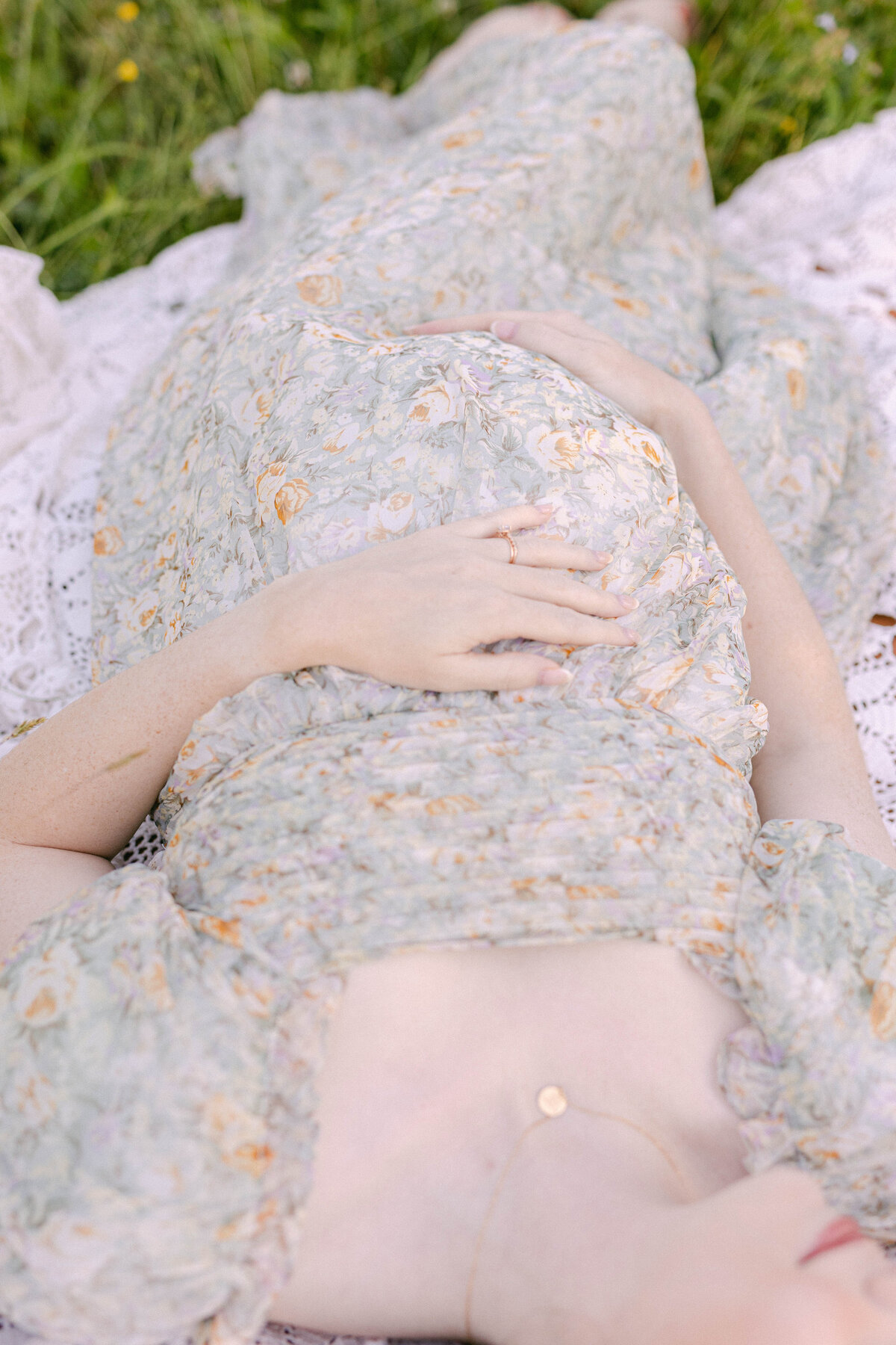 knoxville tennessee newborn photographer pregnant mom laying in grass holding belly