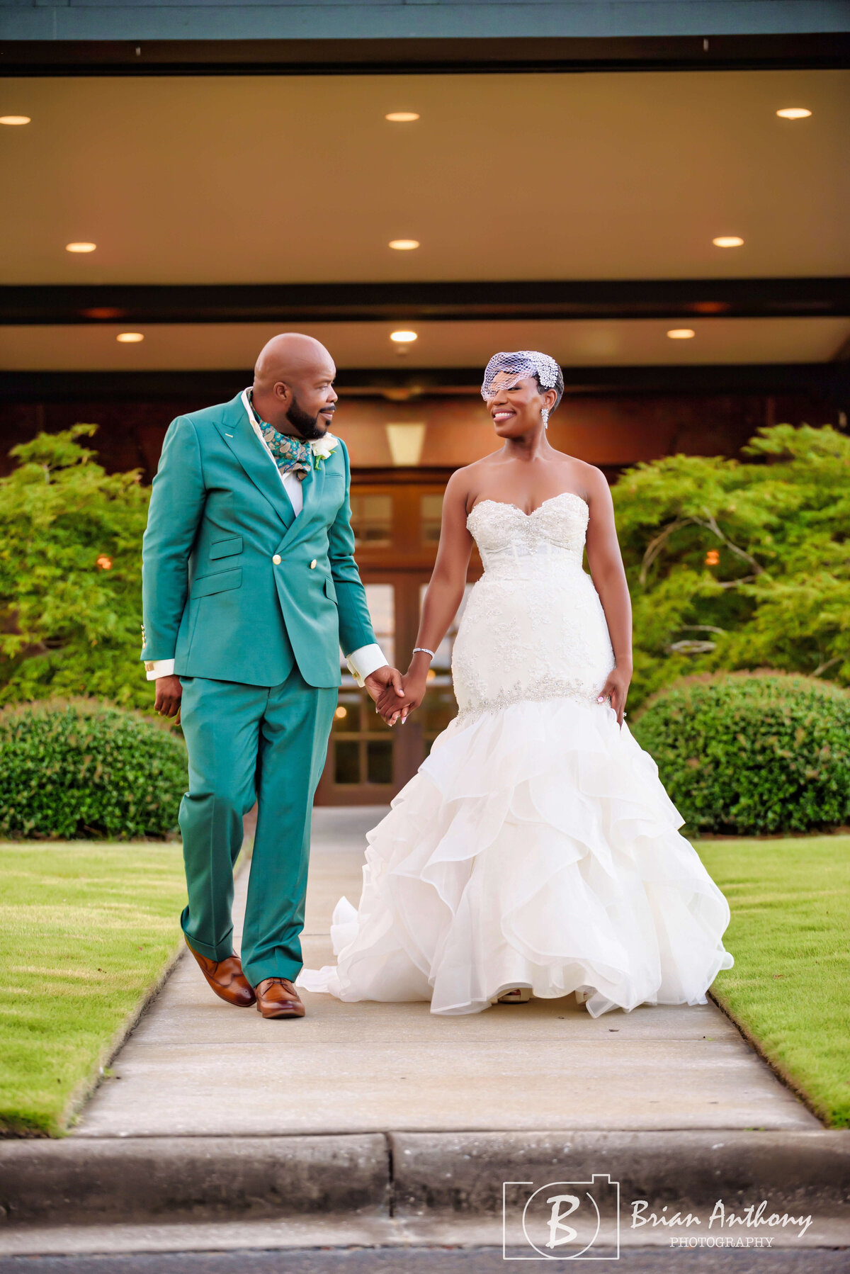 Elegant outdoor wedding portrait of the newlyweds surrounded by lush greenery.