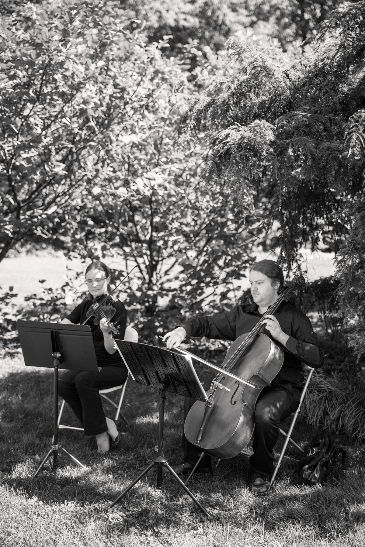 String duo plays at Dayton wedding ceremony outdoors, captured by Philadelphia wedding photographer.