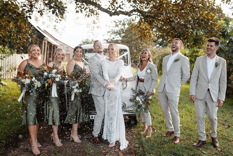 Experience joy and laughter as Maddi & Jeremy, surrounded by their radiant bridal party, create timeless memories during their photoshoot.
