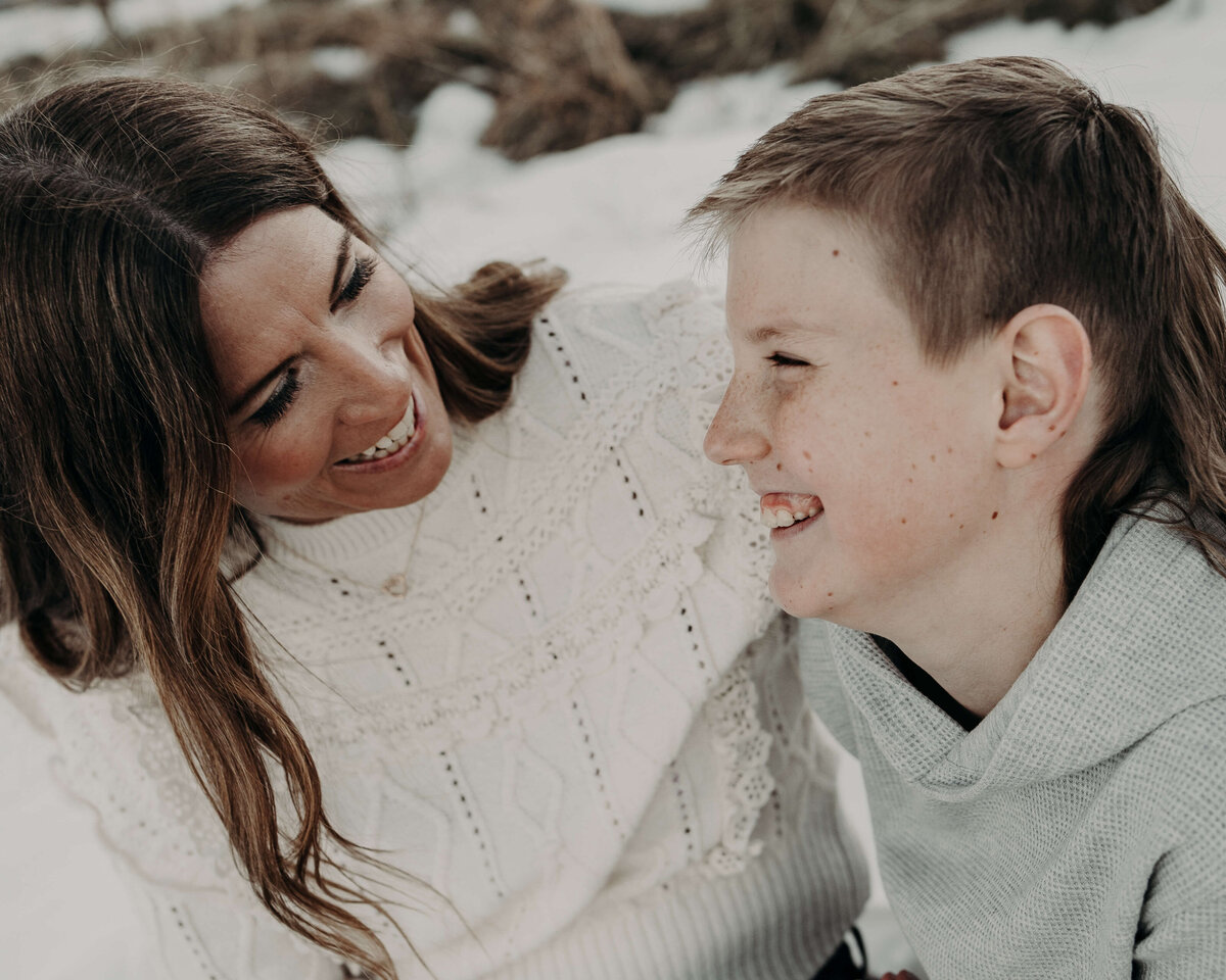 A mom, lovingly engages with her 10-year-old son during an outdoor family photo session.