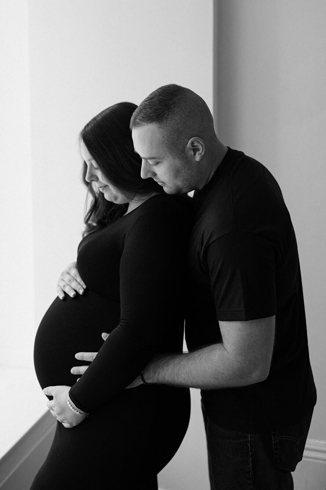 Man with arms around baby bump at  Finger Lakes Maternity session