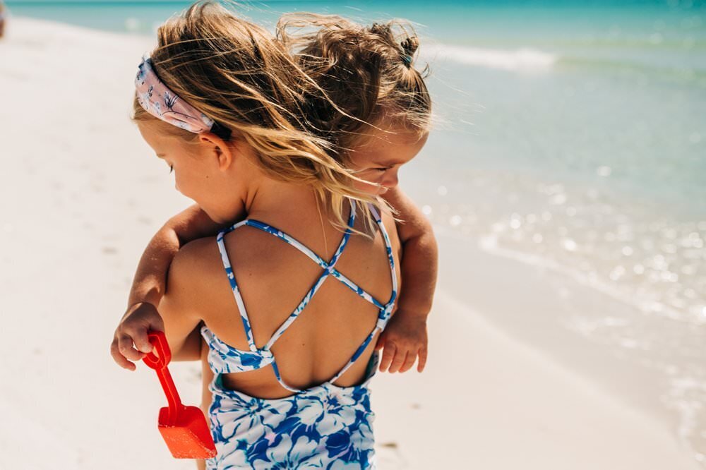 girls hugging on sunny beach of Gulf Coast Florida