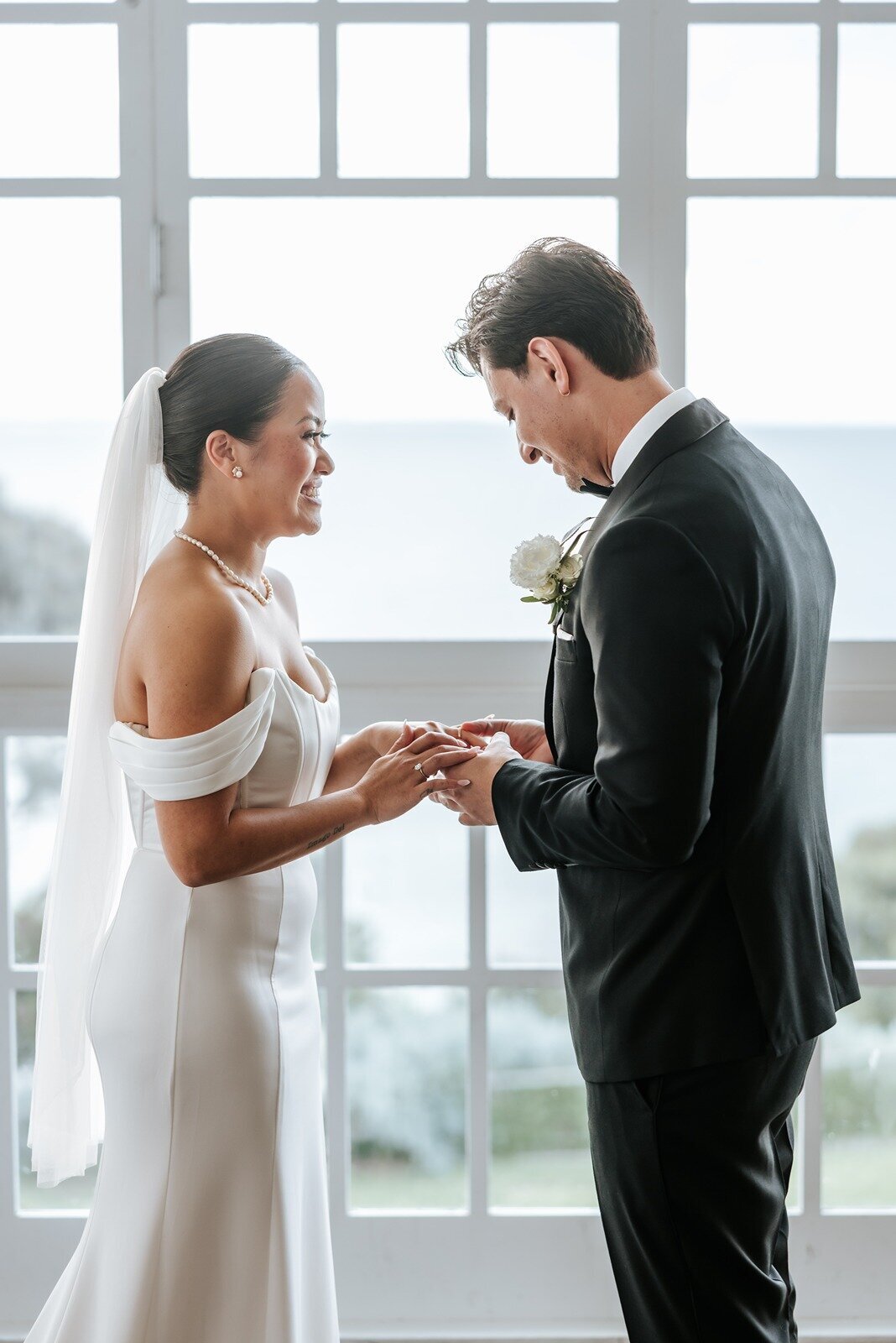 Groom putting a ring on a bride's finger