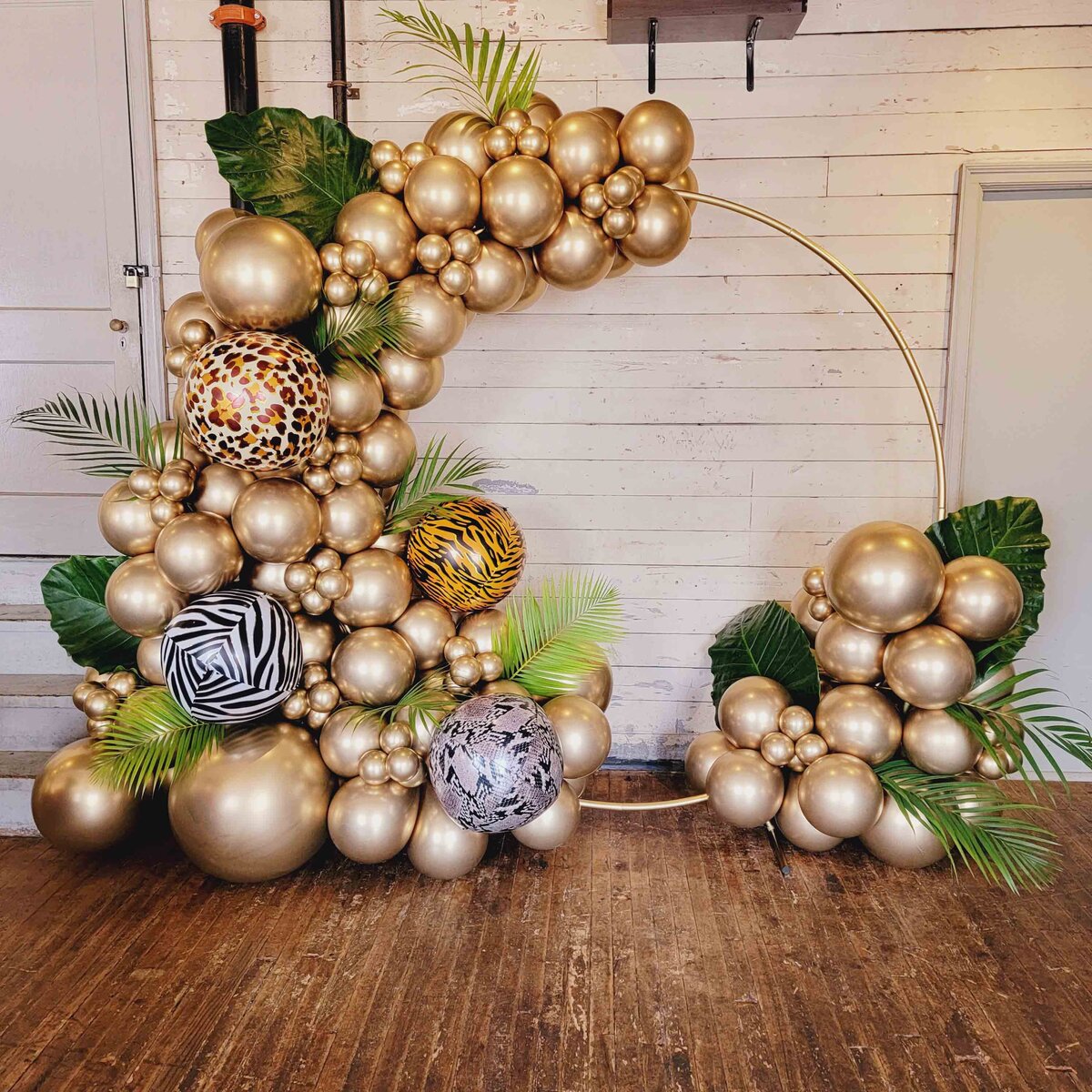 The  event with Air with Flair Decor's Backdrop and Decor Rentals, featuring the timeless elegance of an Arch Gold Balloons setup.