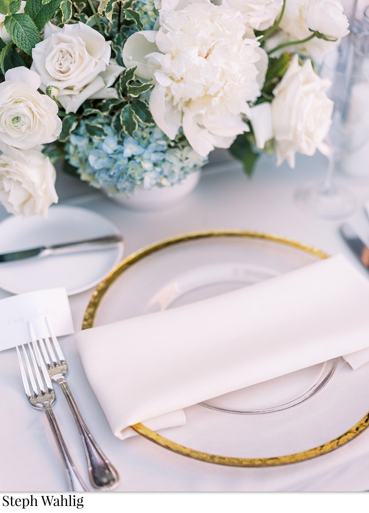 table setting, blue flowers, gold chargers,