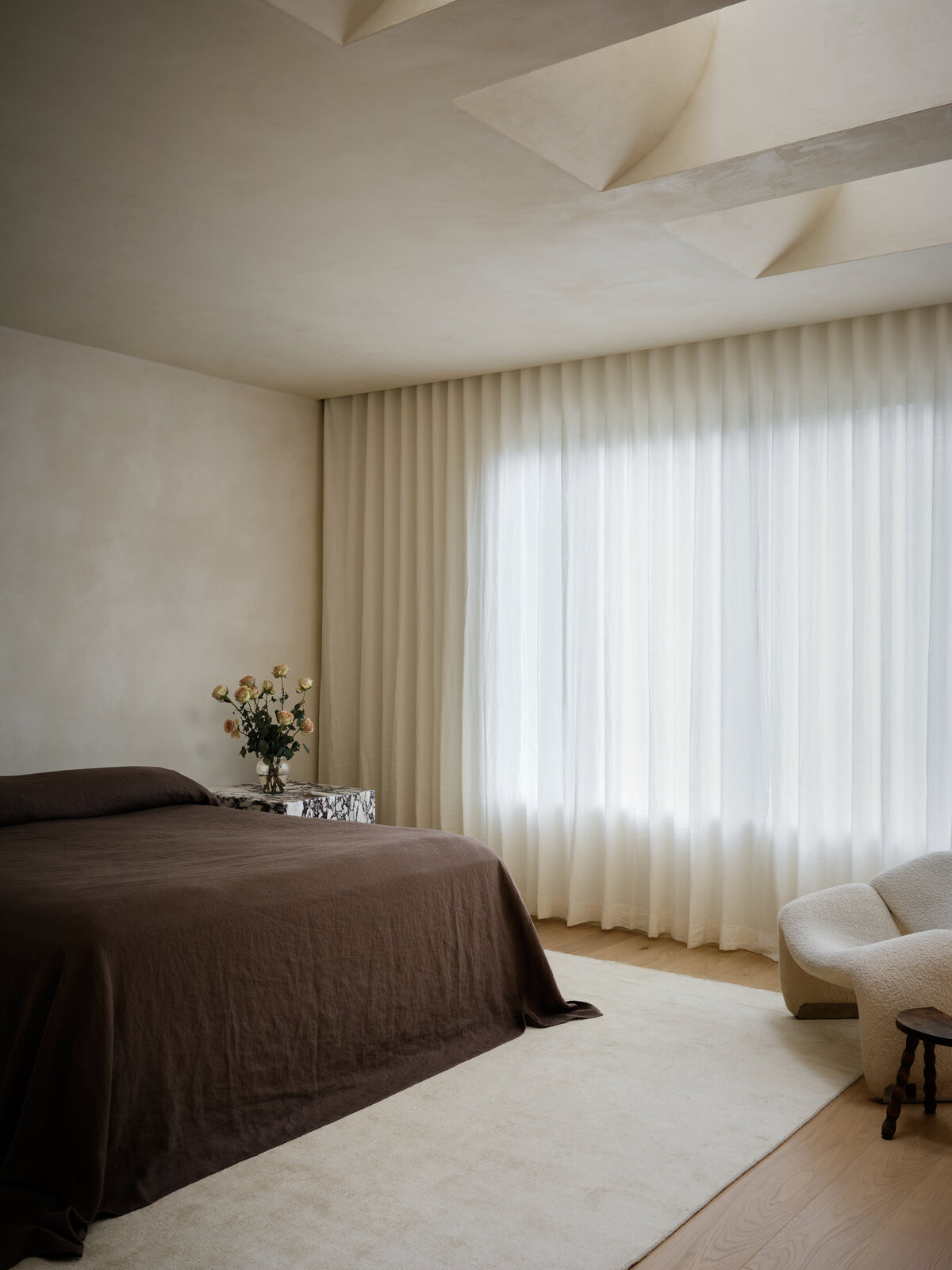 primary-bedroom-linen-curtains-natural-light-plaster-wall-ceiling-curved-skylight-cozy-austin-home-belgian-modern-house-franc