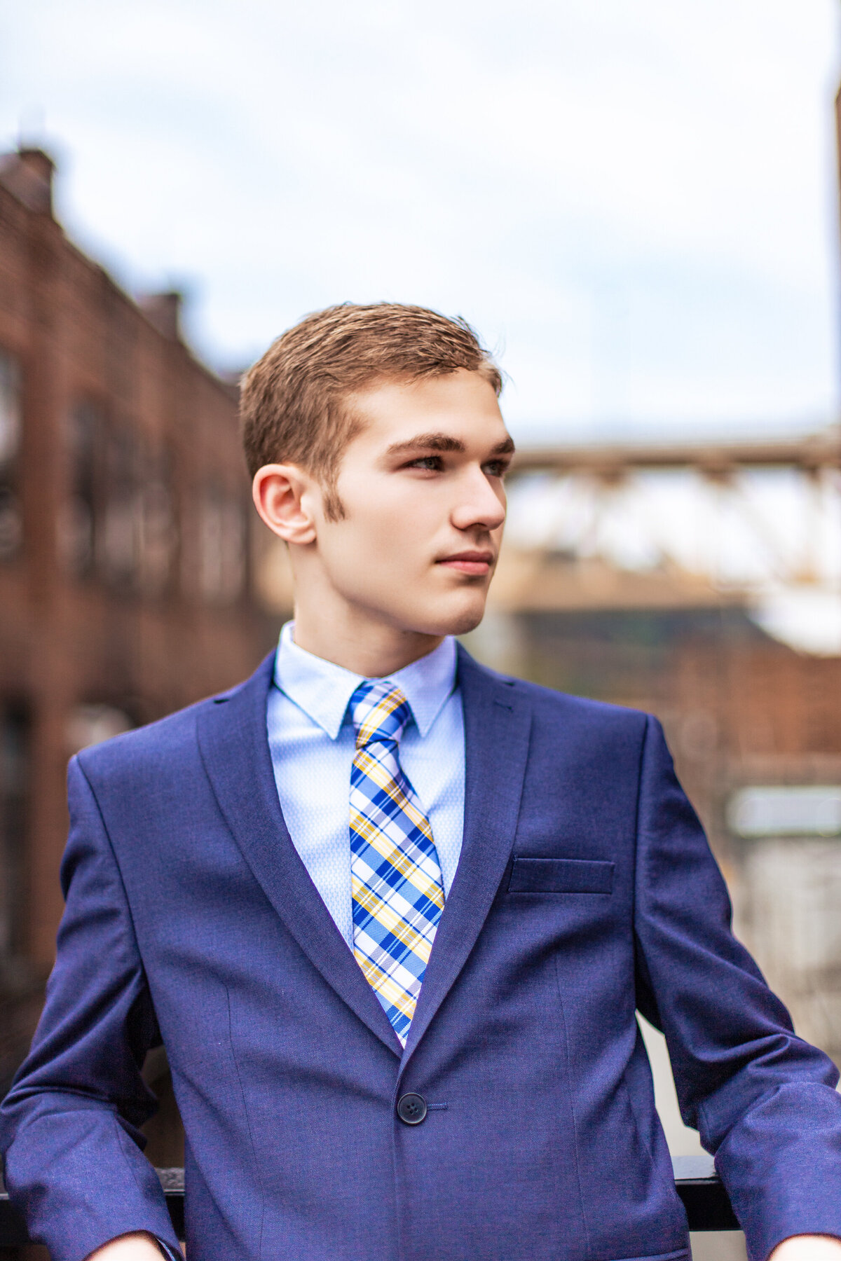 Stylish senior pictures Pittsburgh PA of a boy wearing a suit posing at the highline.