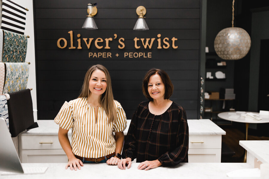 two women smiling behind the front desk at Olivers Twist
