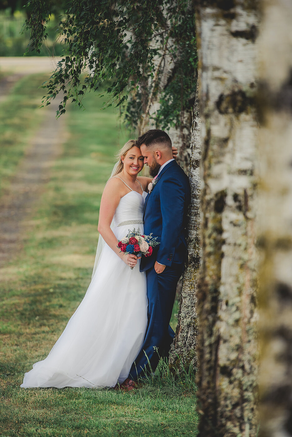 bride and groom leaning on tree