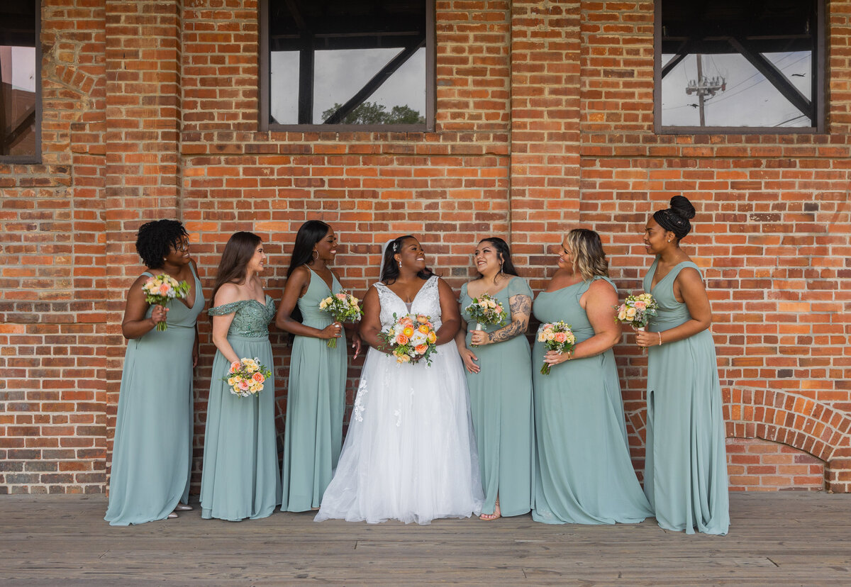 bride and bridesmaids wearing sage green dresses at Columbus Trade and Convention Center by Georgia wedding photographer Amanda Richardson Photography