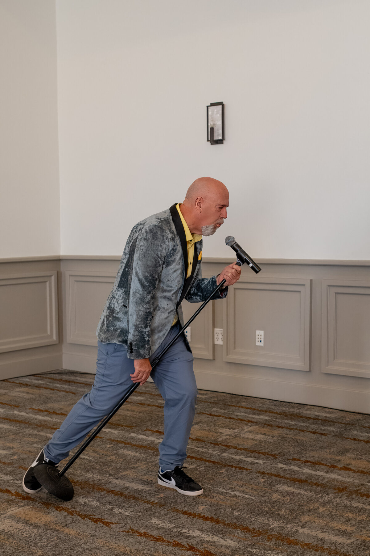 Man energetically speaking into a microphone during an indoor event, captured by Vyrl Photo for Tucson event and brand photography.