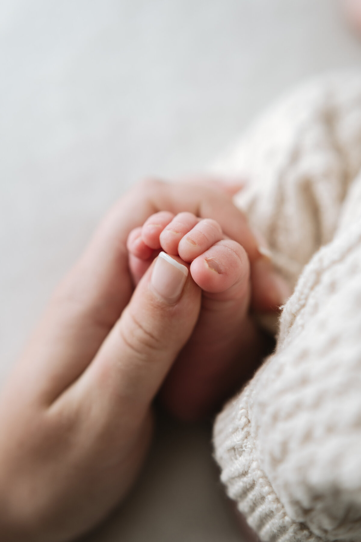 Mum holding babies toes at newborn photoshoot in Billingshurst