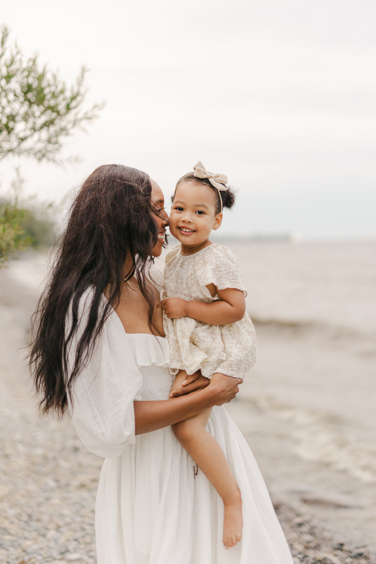 A mother is holding her daughter close at a Toronto beach family session