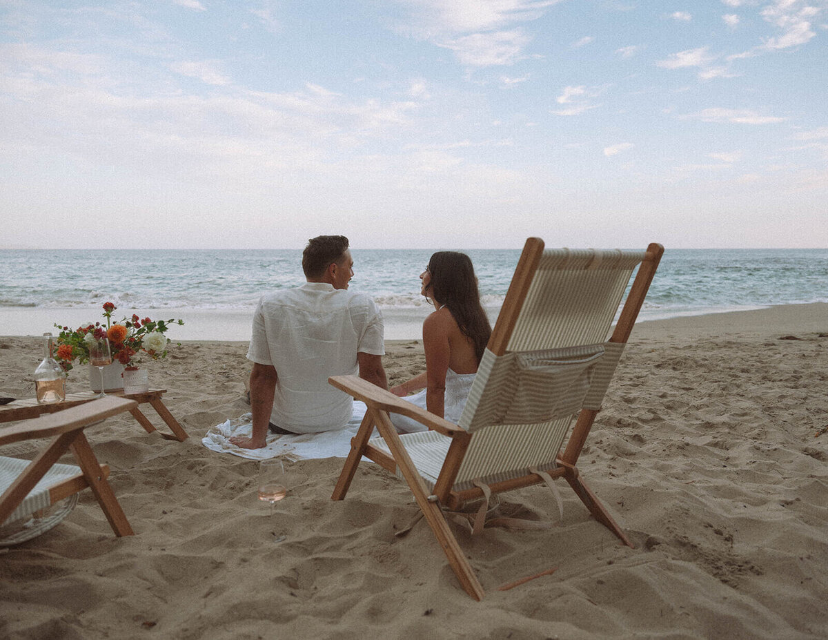Couple enjoying a beach picnic setup during a Laguna Beach photography session in Orange County, California.