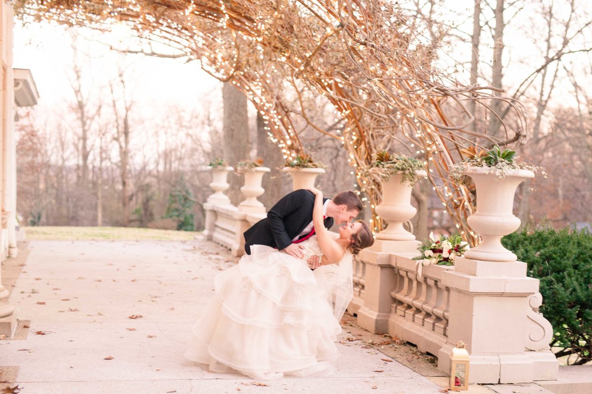 A couple shares a kiss under the gazebo with Gramercy Mansion Wedding Photographer
