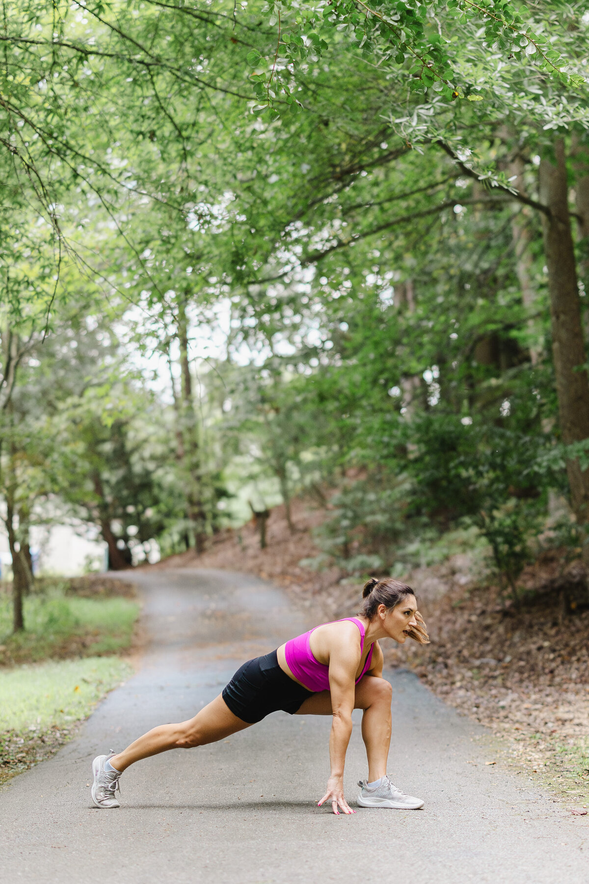 A person stretches in the woods.