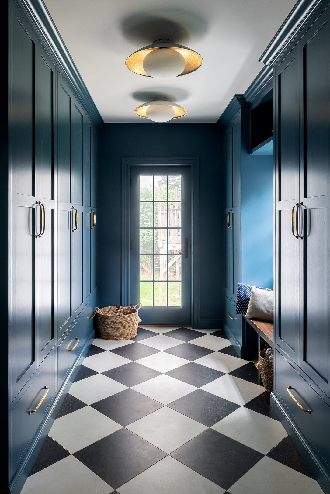 mudroom entryway with checkered tiles and blue green walls