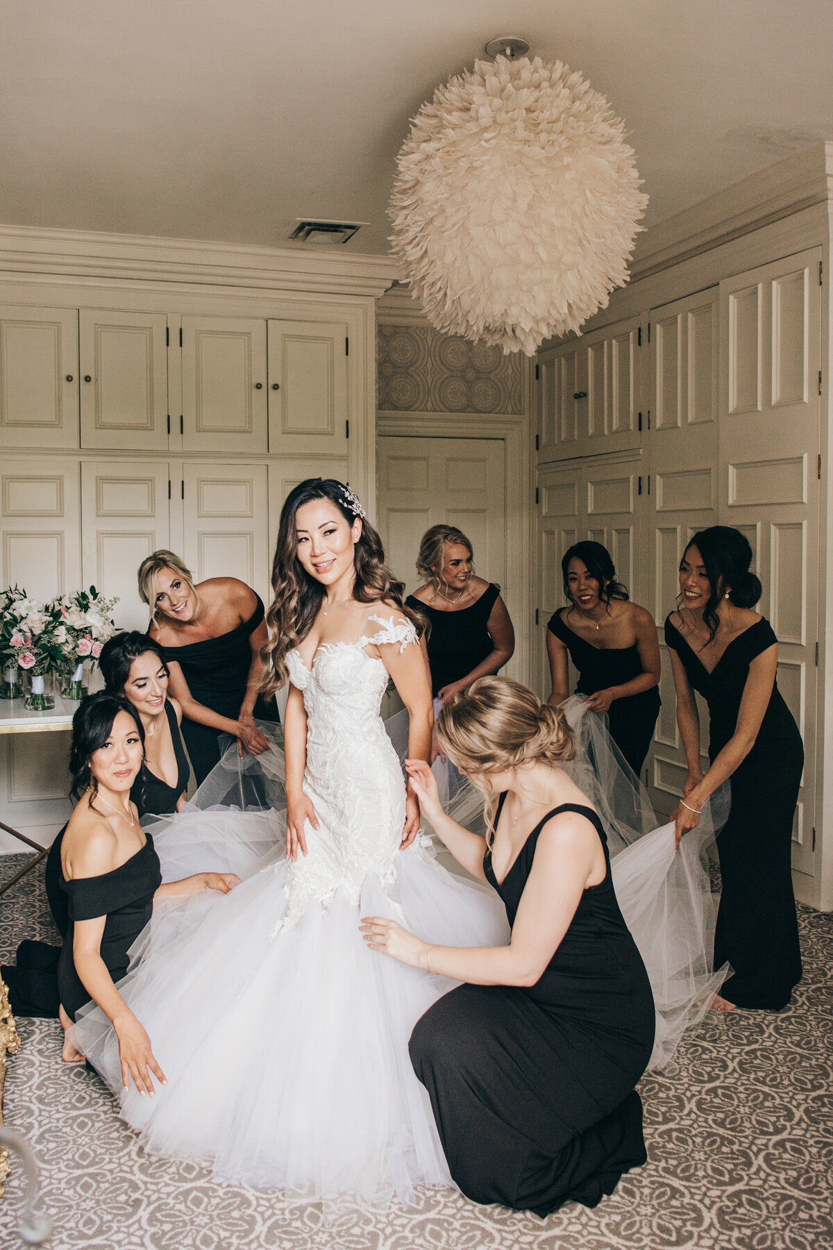 Bride getting ready with the help of bridesmaids in black
