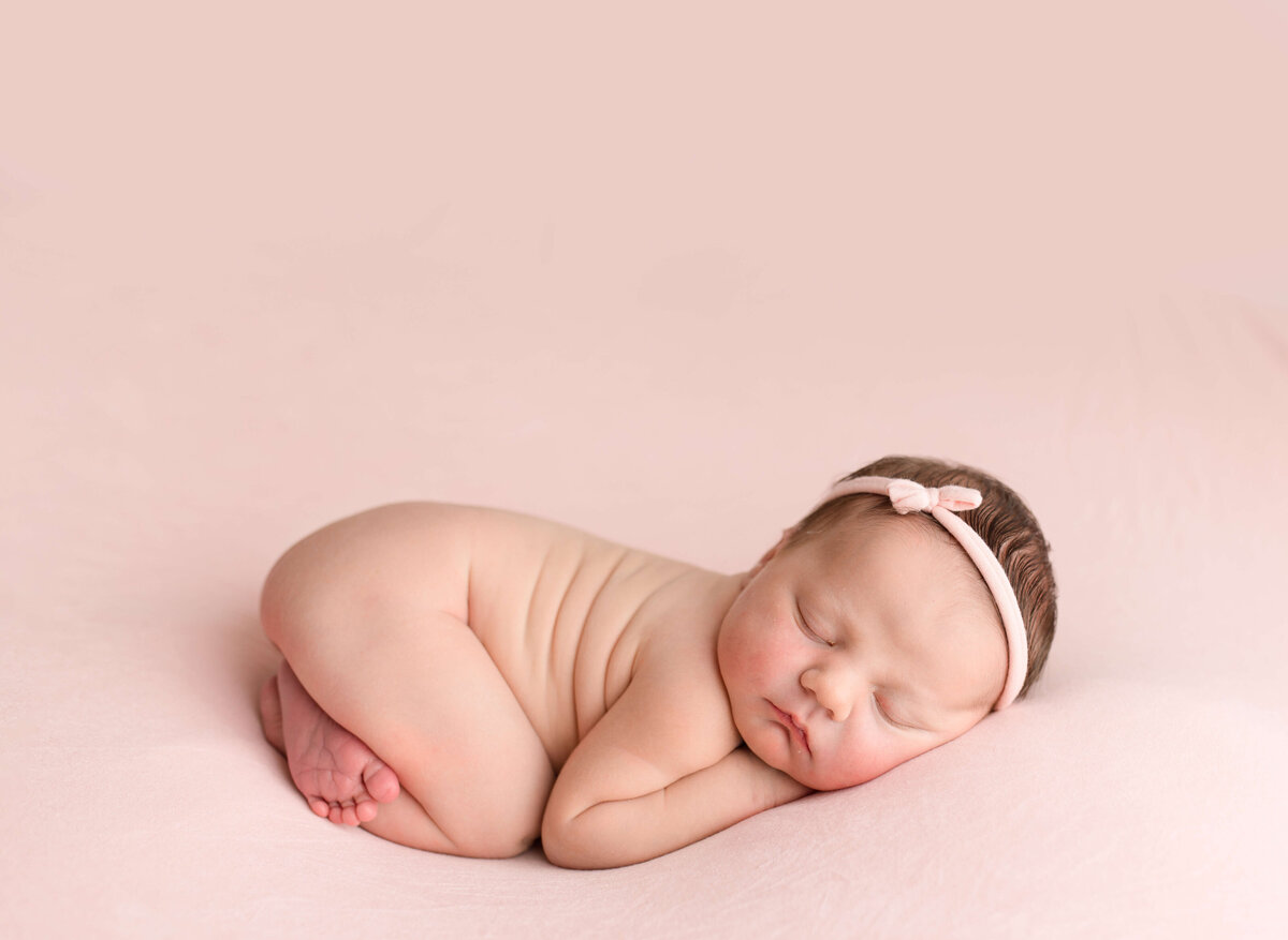 sleepy baby girl on pink fabric