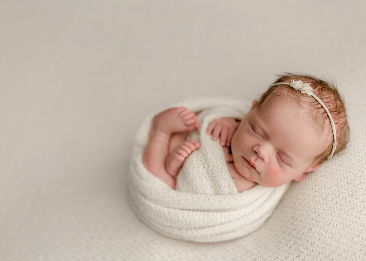 baby girl posed on cream fabric in denver studio