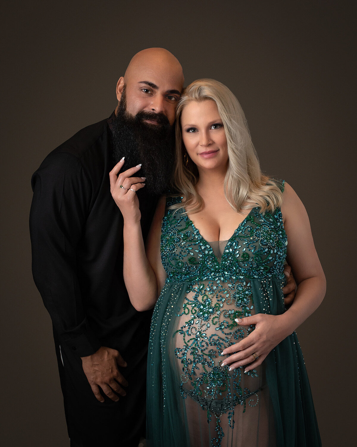 Stunning couple expecting their first baby in Houston, Texas. Mom is wearing an emerald green couture gown. Dad is wearing an  India n kurta in black.