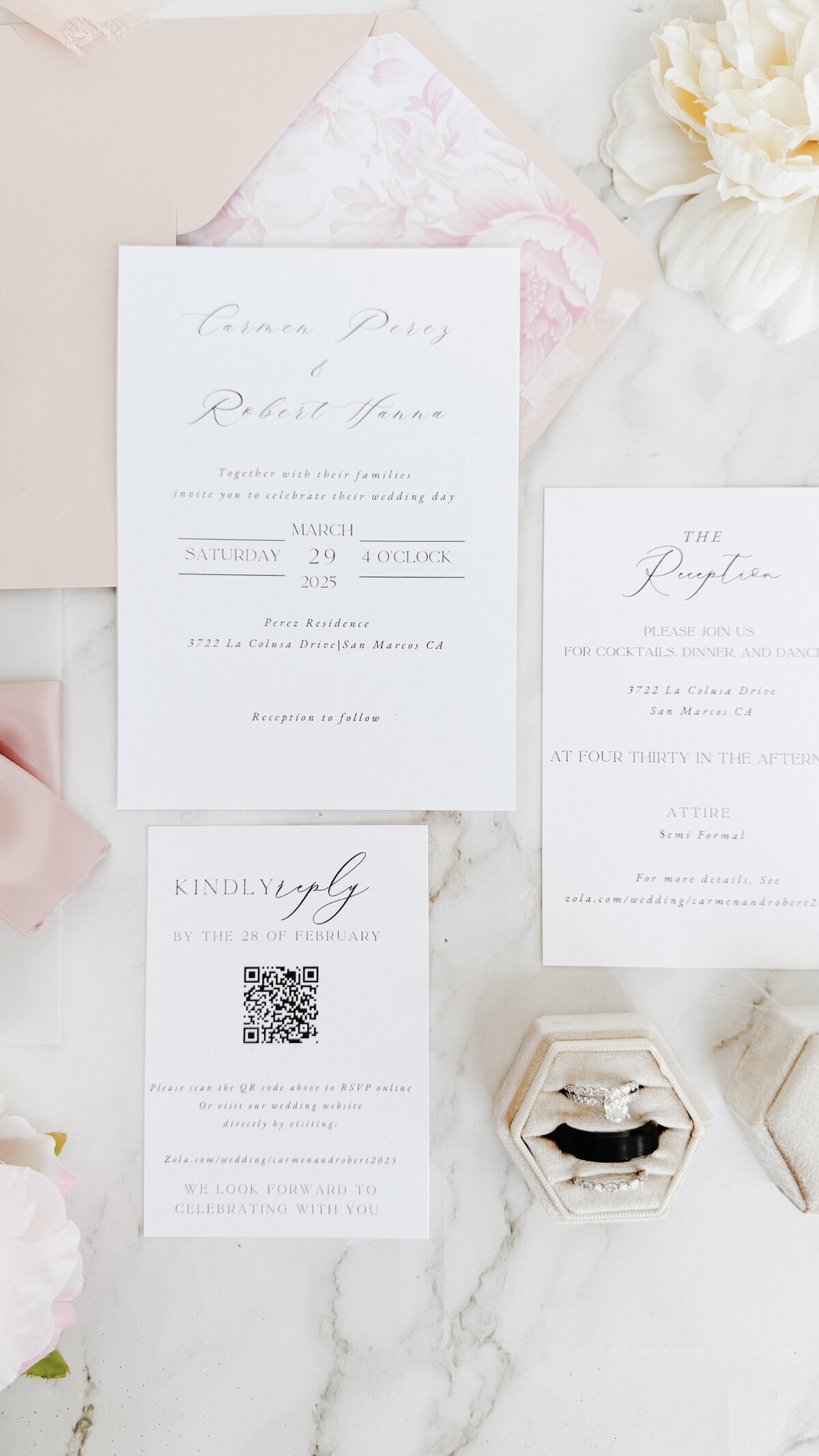 Wedding invitation with RSVP card and reception details card laying on a white mat with pink ribbon.