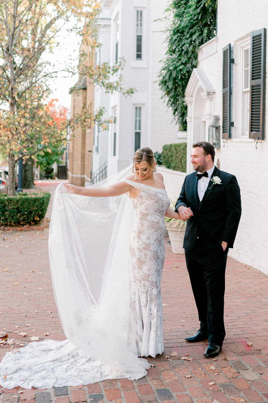 Fun image of a bride and groom dancing together as she looks down at her dress, captured in Georgetown