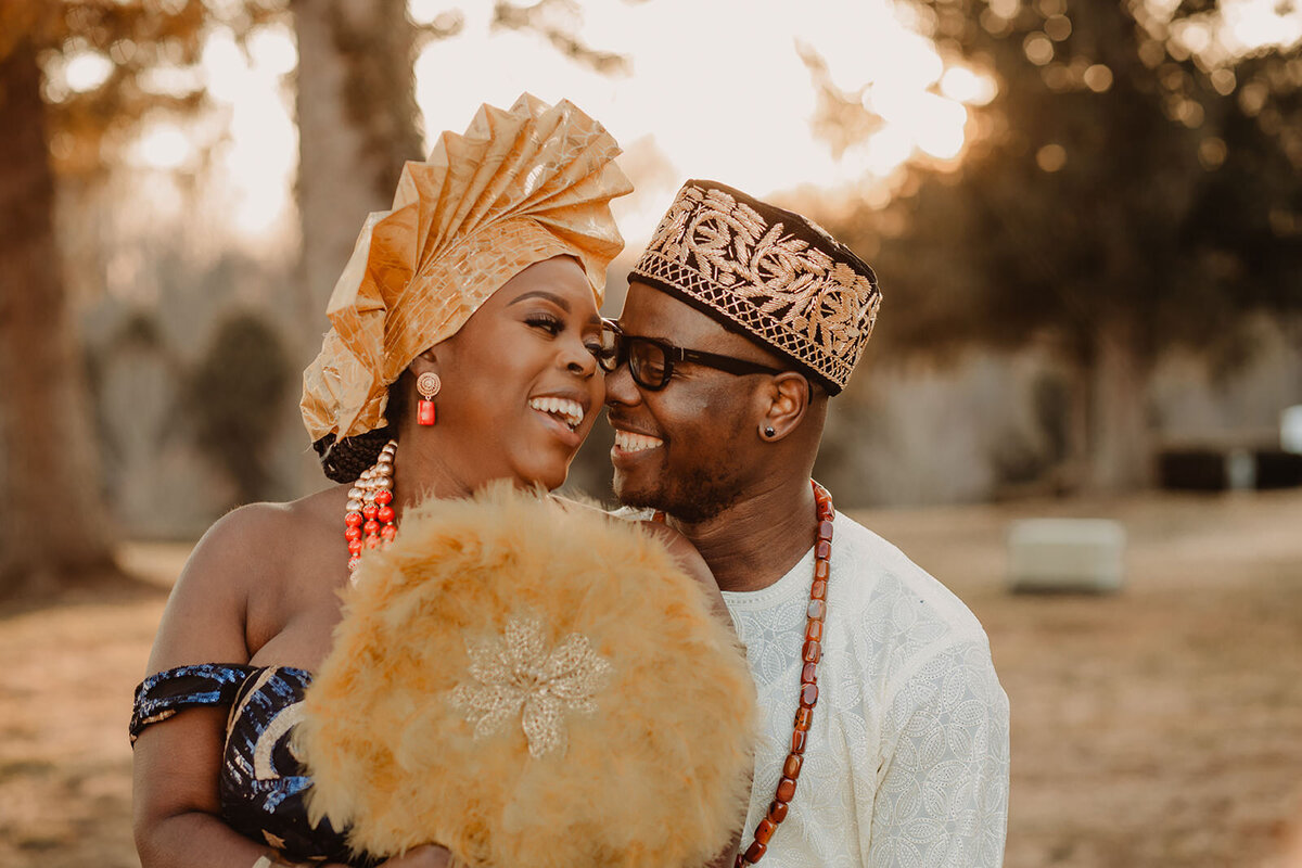 A wedding couple standing close together and laughing 