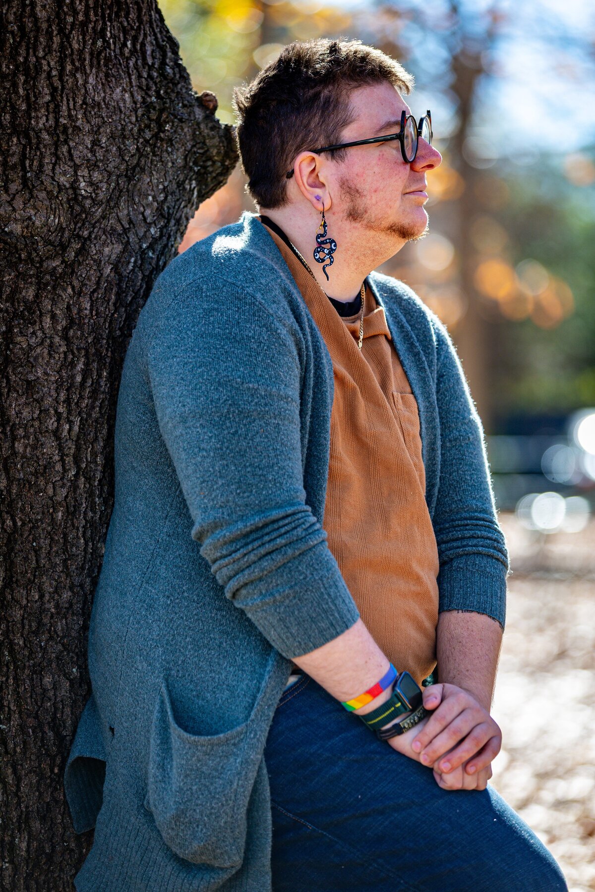 A person leaning against a tree.