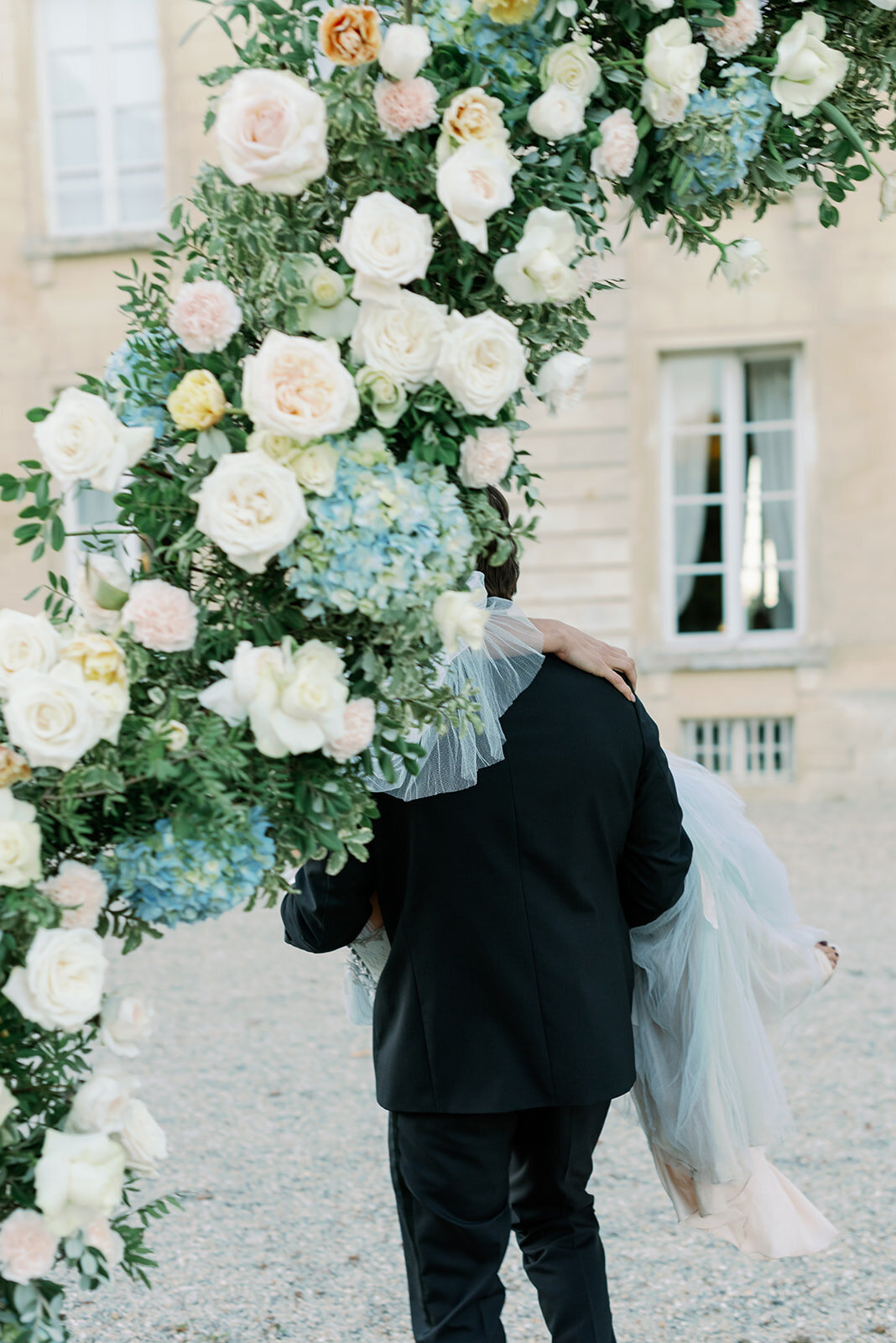 Bröllopsfotograf i Stockholm helloalora Anna Lundgren destination slottsbröllop på Chateau de Courtomer i Normandie Frankrike brudpar vid blomsterbåge efter vigsel
