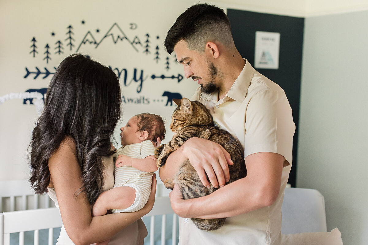 family of three and cat in nursery