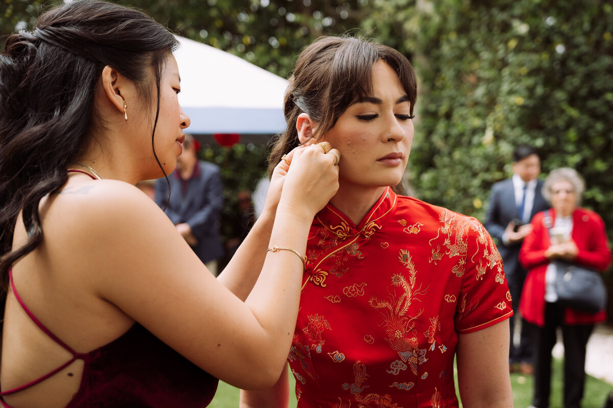 beautiful bride preparing for wedding ceremony with bridesmaid