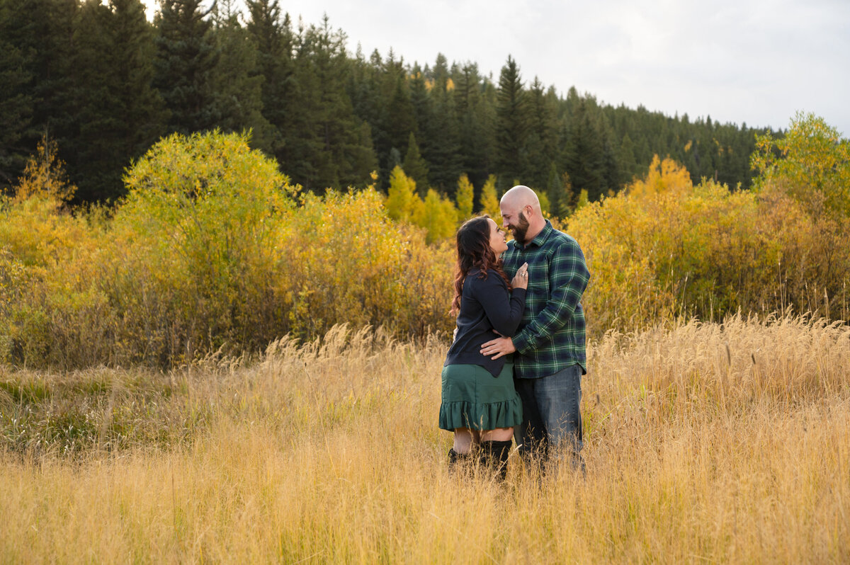 Couples session in Golden Colorado during fall season next to small pond