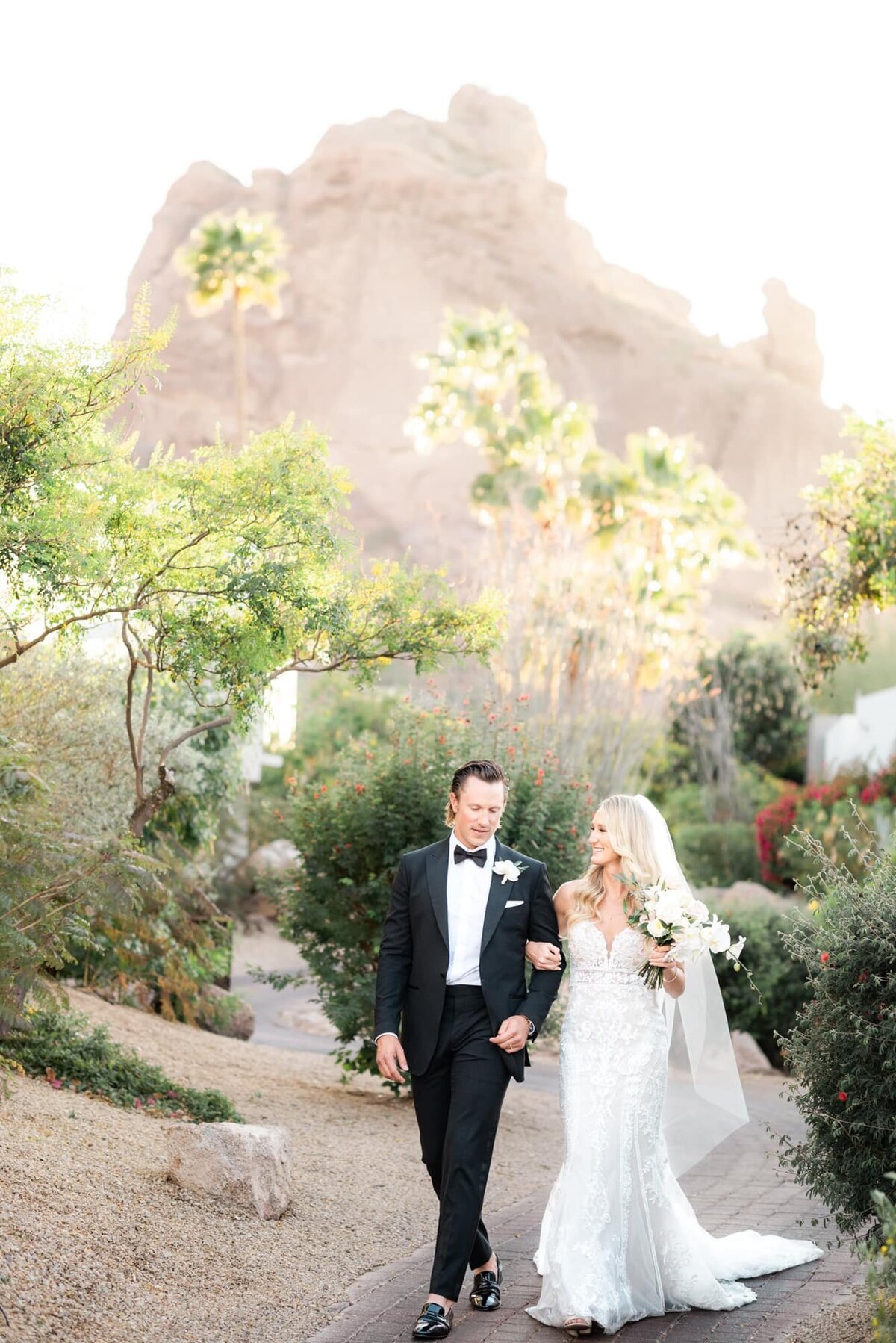 Bride and groom walking with mountain views behind them at a destination wedding
