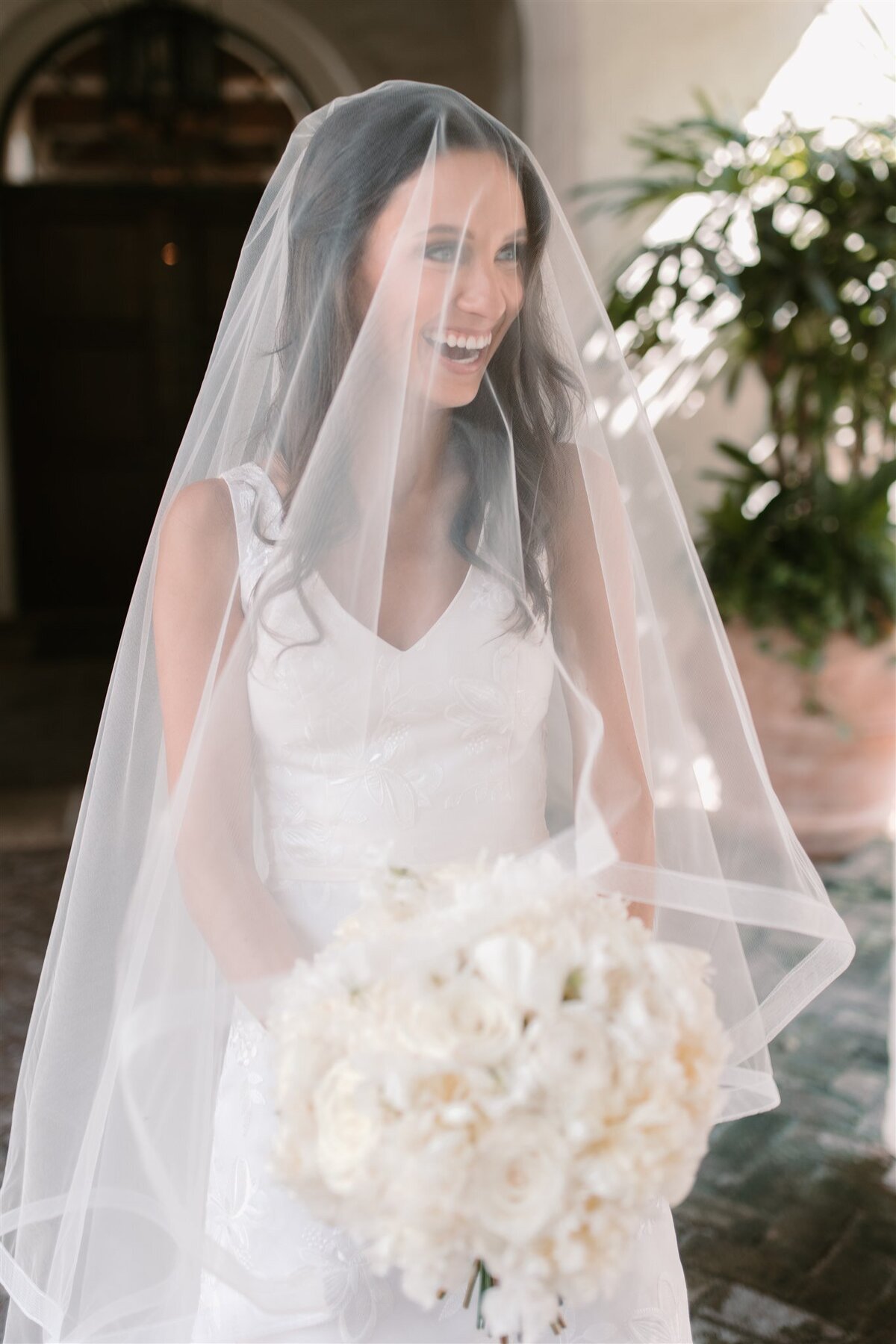 bride wearing veil and holding white bouquet