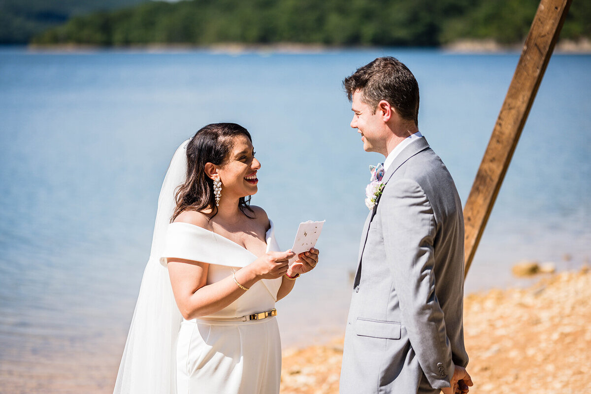 A bride reads her vows to her partner on their elopement day along the shores of Carvin’s Cove in Roanoke, Virginia.