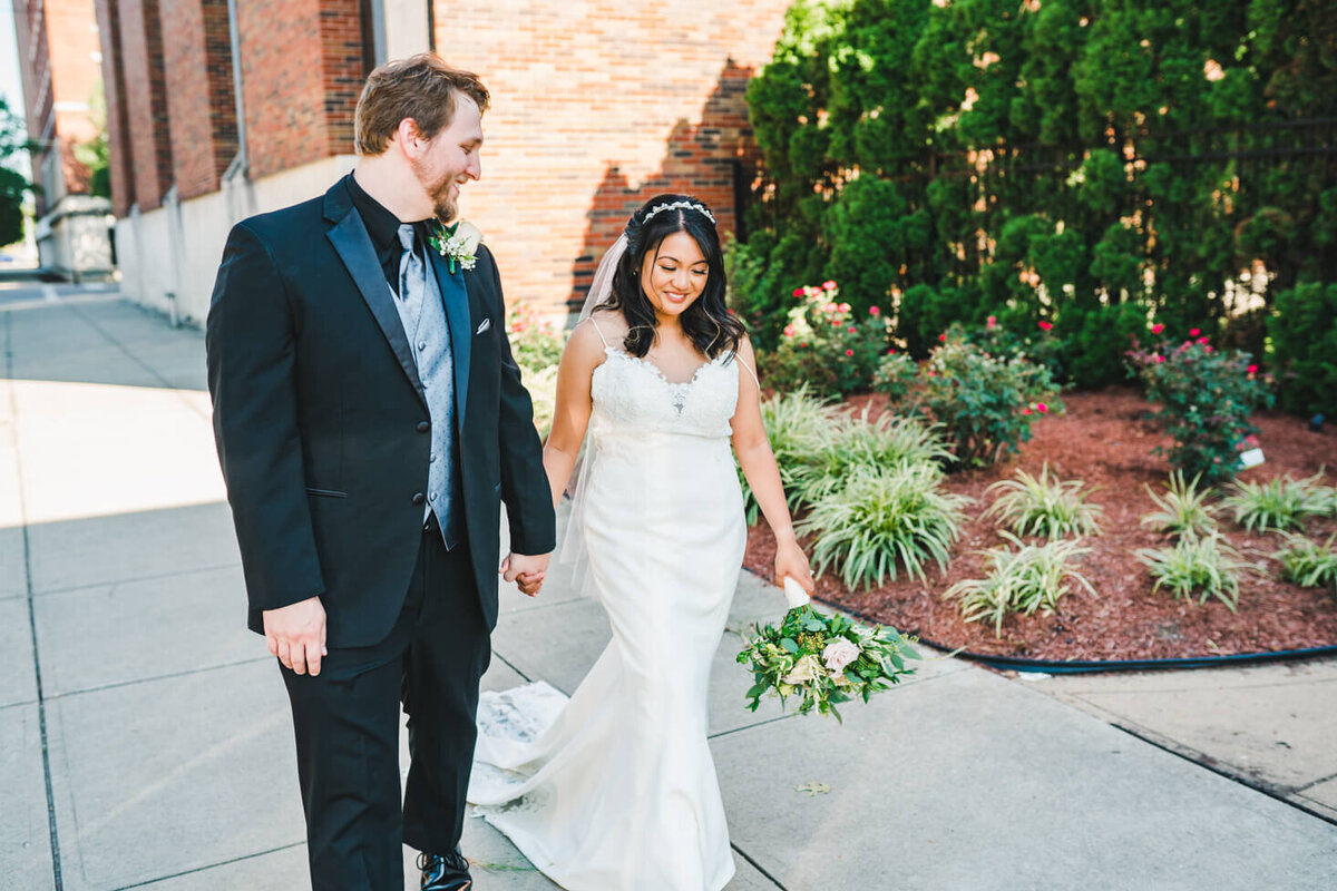 Photo of the bride and groom talking and walking to their reception venue in Hamilton, OH.