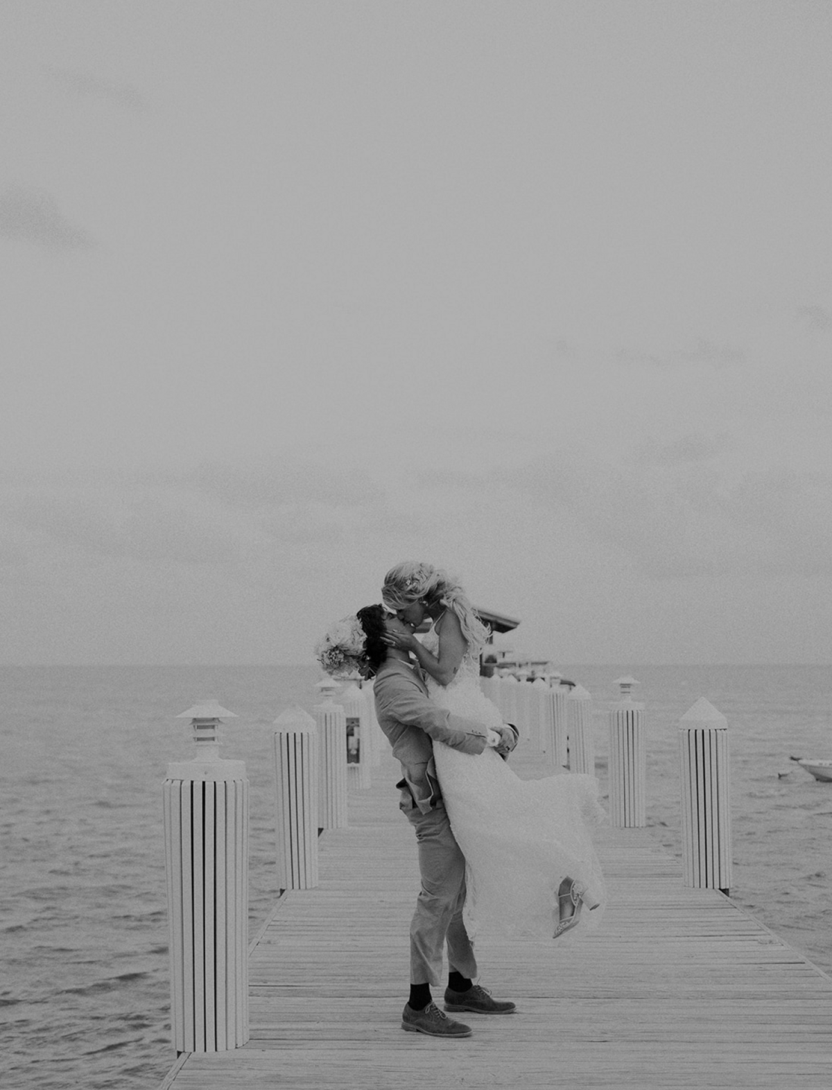 Bride and groom sharing a romantic kiss on a dock during their Miami wedding, captured by Claudia Amalia, a wedding and lifestyle photographer based in Miami and Florida Keys, South Florida. Destination weddings available. Portfolio highlight.