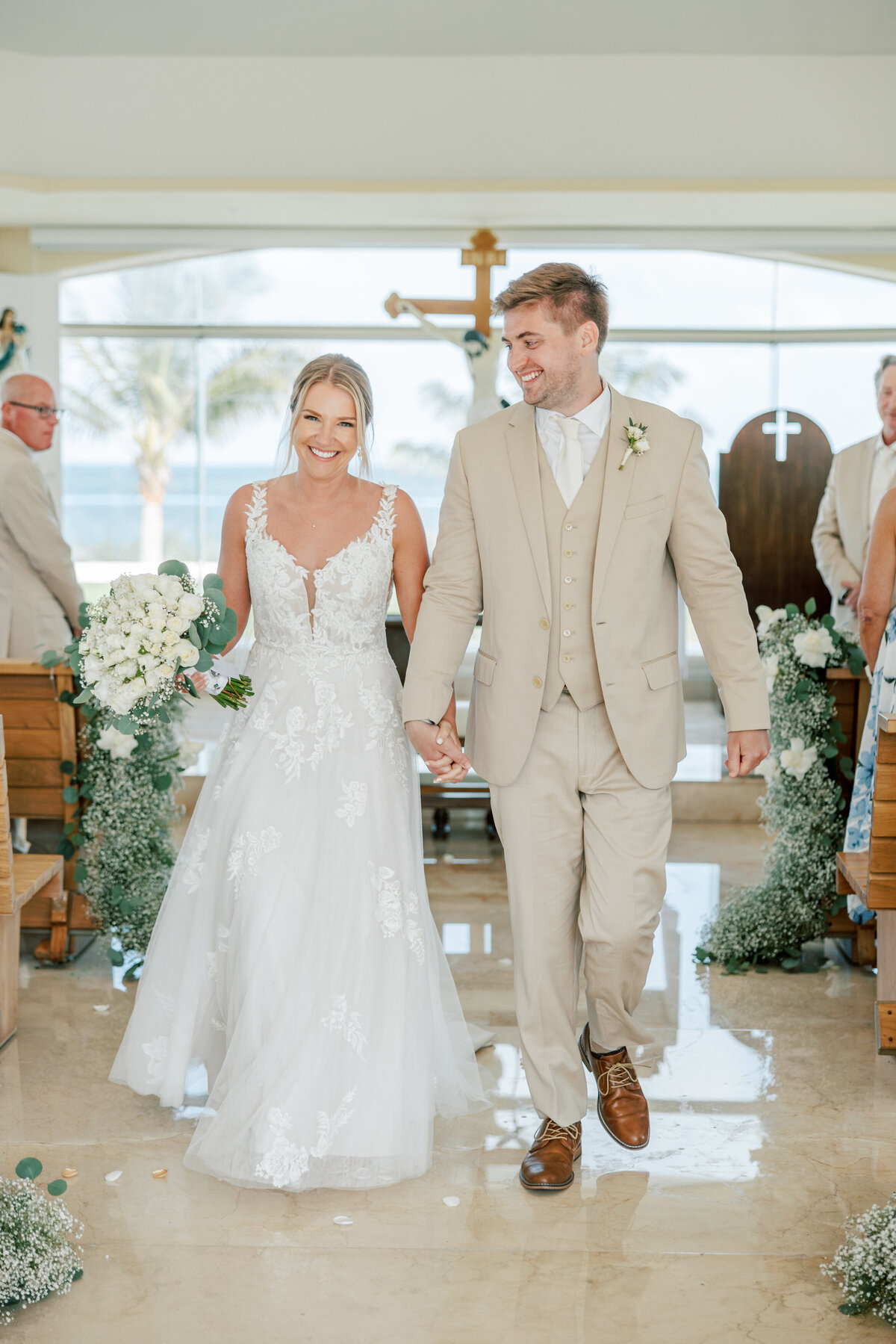 Newlyweds walk back down the aisle smiling at Cancun destination wedding, Philly photographer.