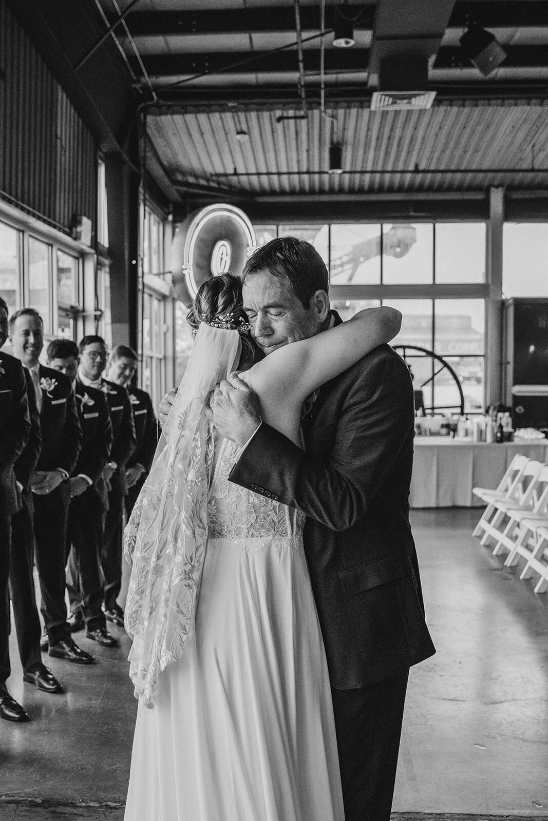 A parent hugging their child during their wedding ceremony 