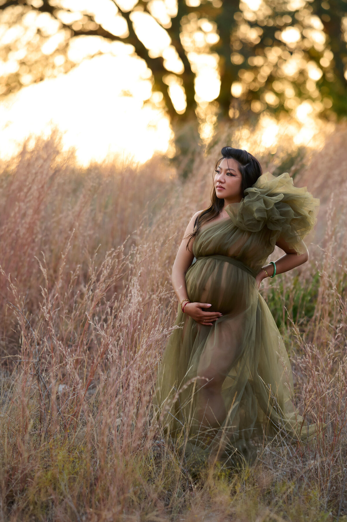 Outdoor maternity photography session in golden prairie field during natural lighting