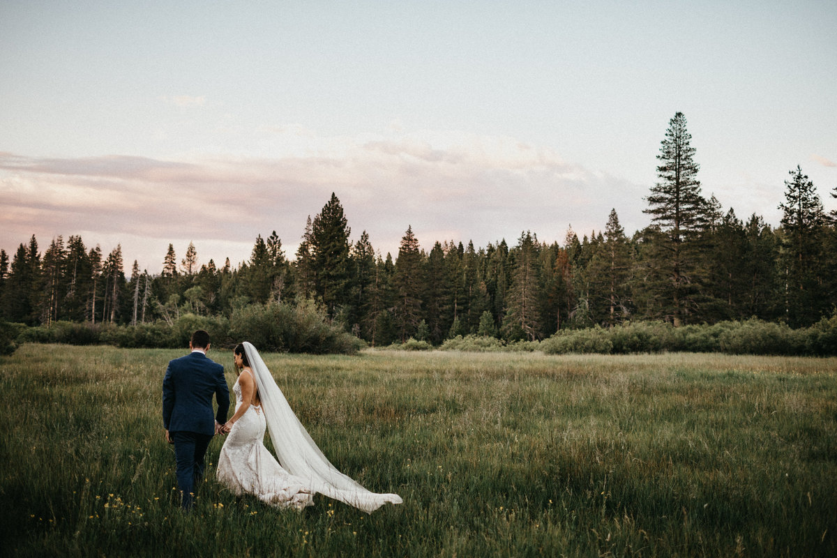 Tahoe Wedding Planners couple walking in meadow at summer wedding venue Mitchell's Mountain Meadows Sierraville near Truckee, Joy of Life Events image by Lukas Koryn