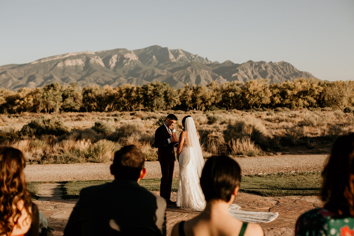 bride and groom holding hands while saying vows